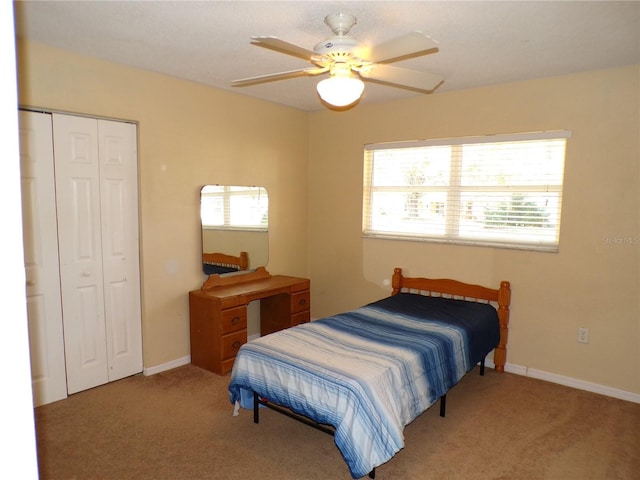 bedroom with carpet floors, ceiling fan, baseboards, and a closet