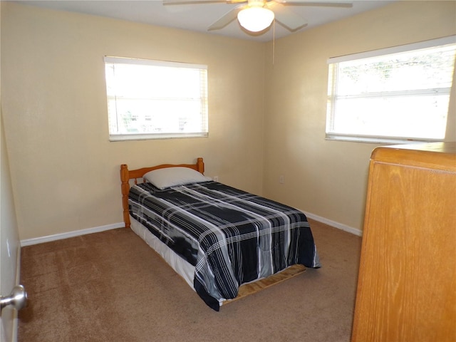 bedroom with a ceiling fan, carpet flooring, and baseboards