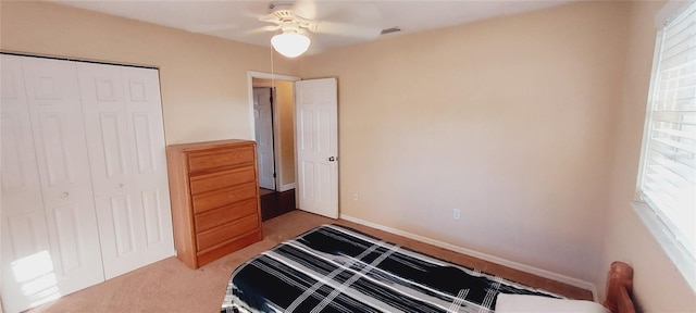 bedroom with baseboards, a ceiling fan, a closet, and carpet flooring