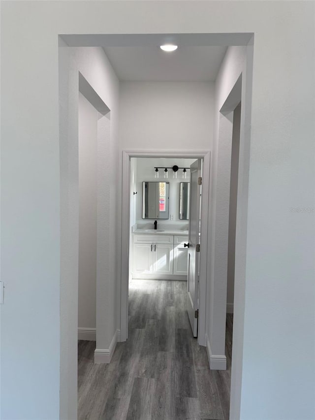 corridor featuring dark wood-type flooring and sink