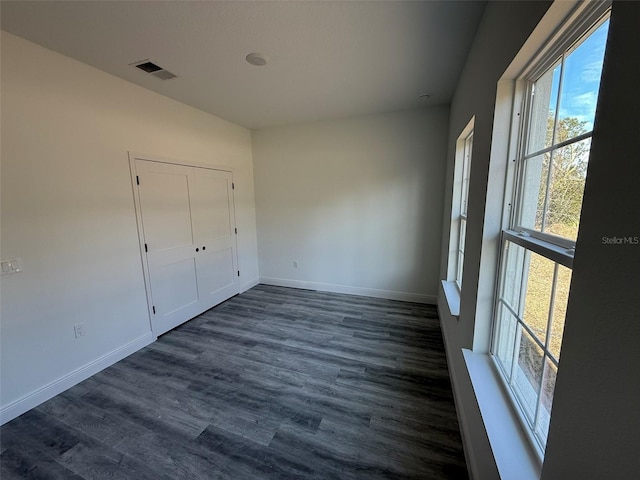 unfurnished bedroom featuring a closet and dark hardwood / wood-style flooring