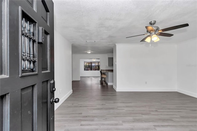 foyer featuring a textured ceiling, ceiling fan, and light hardwood / wood-style flooring