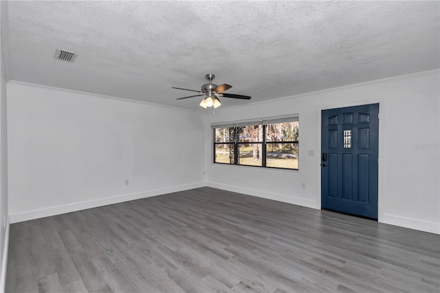 interior space featuring hardwood / wood-style flooring, ceiling fan, ornamental molding, and a textured ceiling