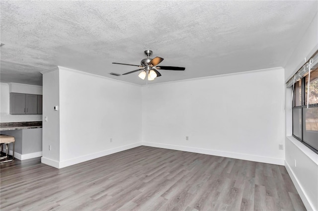 unfurnished living room with crown molding, ceiling fan, light hardwood / wood-style floors, and a textured ceiling