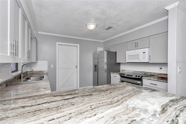 kitchen with light stone counters, ornamental molding, appliances with stainless steel finishes, and sink