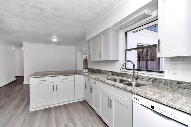 kitchen with sink, white cabinets, white dishwasher, kitchen peninsula, and light wood-type flooring