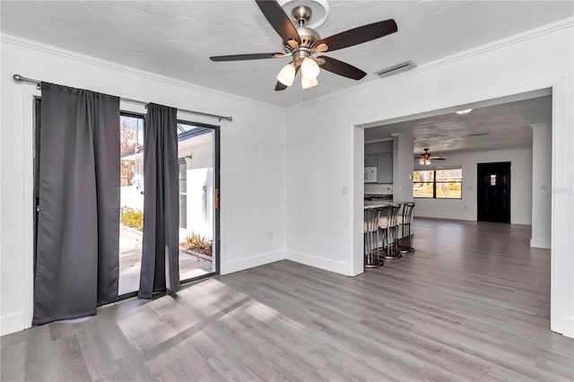 spare room with hardwood / wood-style flooring, crown molding, and ceiling fan