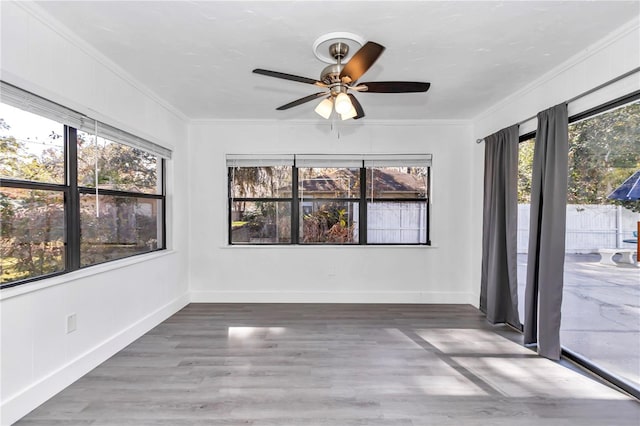 unfurnished sunroom with ceiling fan