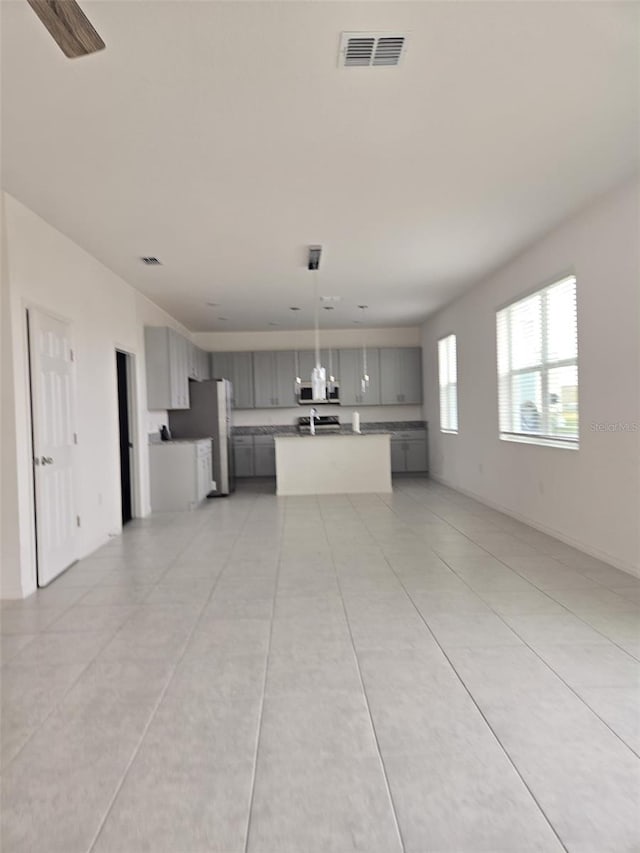 1603 Gardiner St, Haines City, FL 33844 - kitchen with visible vents, a kitchen island, open floor plan, hanging light fixtures, and gray cabinetry