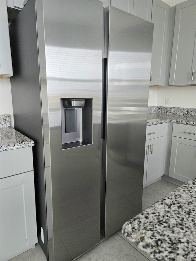 1603 Gardiner St, Haines City, FL 33844 - kitchen with light stone counters, stainless steel fridge, and light tile patterned floors