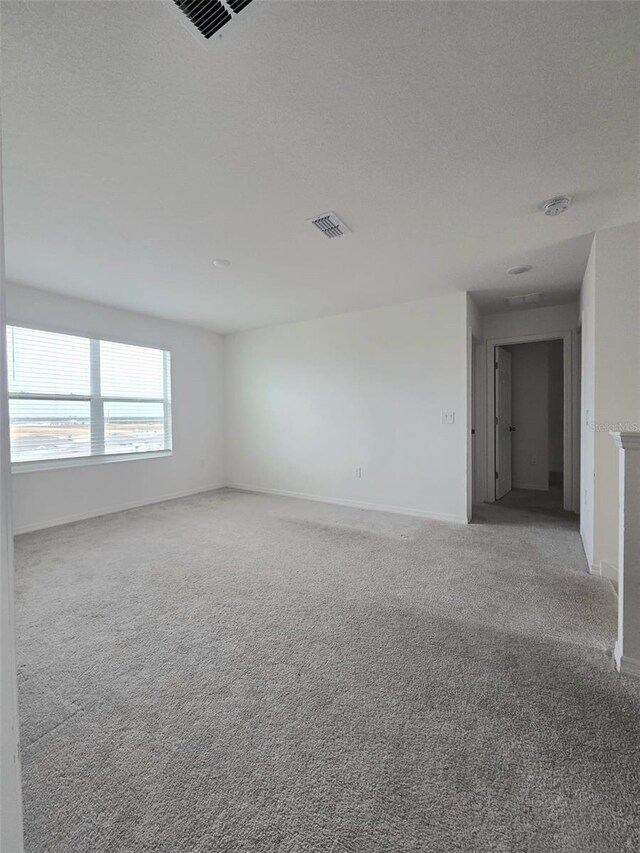 1603 Gardiner St, Haines City, FL 33844 - spare room with baseboards, visible vents, a textured ceiling, and light colored carpet