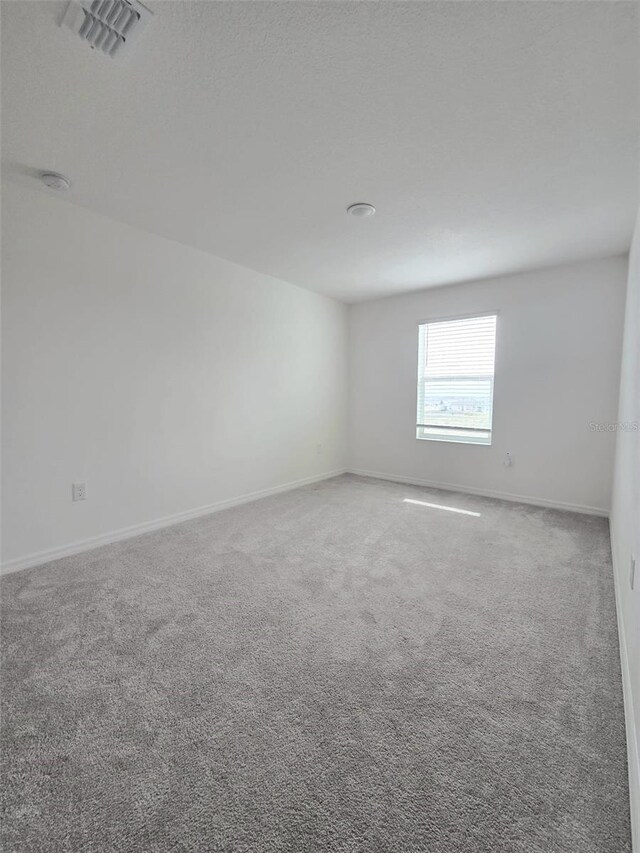 1603 Gardiner St, Haines City, FL 33844 - spare room with baseboards, visible vents, a textured ceiling, and carpet flooring