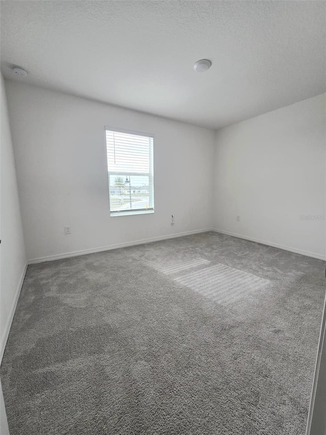 1603 Gardiner St, Haines City, FL 33844 - spare room with a textured ceiling, dark colored carpet, and baseboards