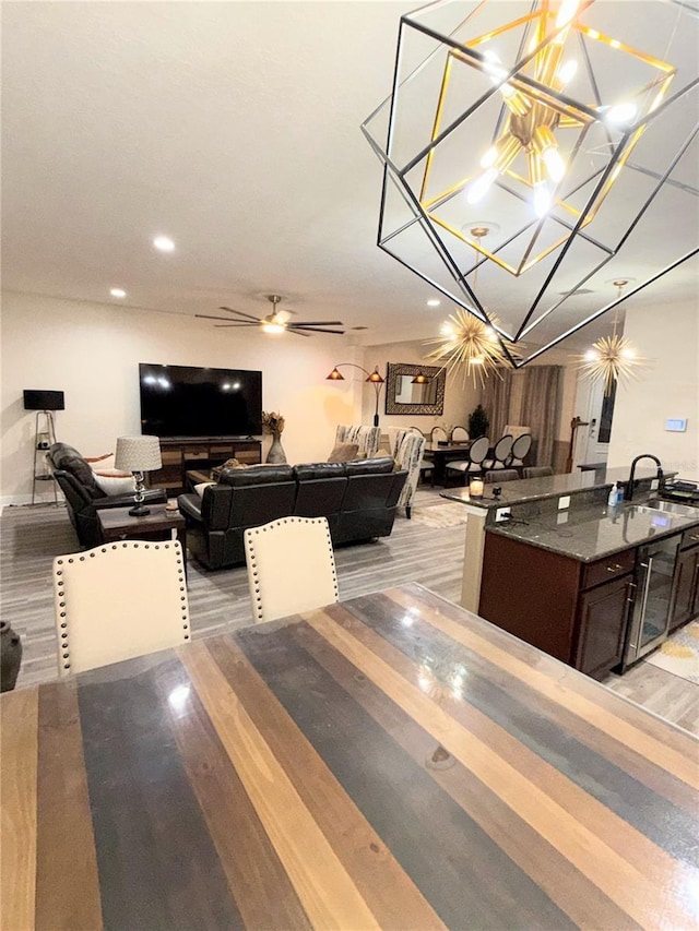 dining area with sink and ceiling fan with notable chandelier