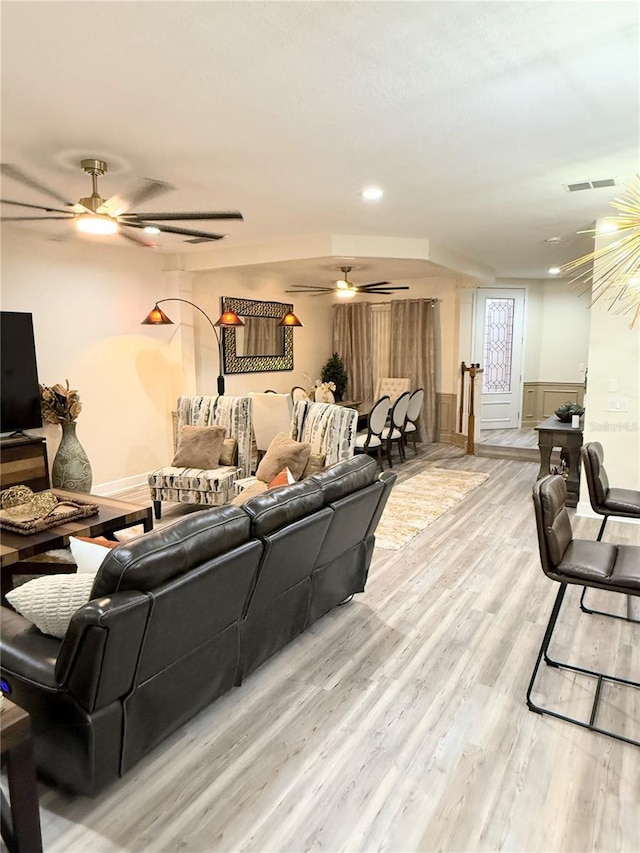 living room featuring ceiling fan and light hardwood / wood-style floors