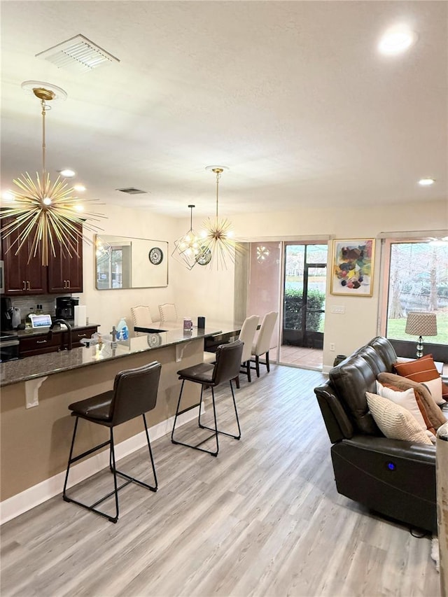 interior space featuring light wood-type flooring, sink, and an inviting chandelier