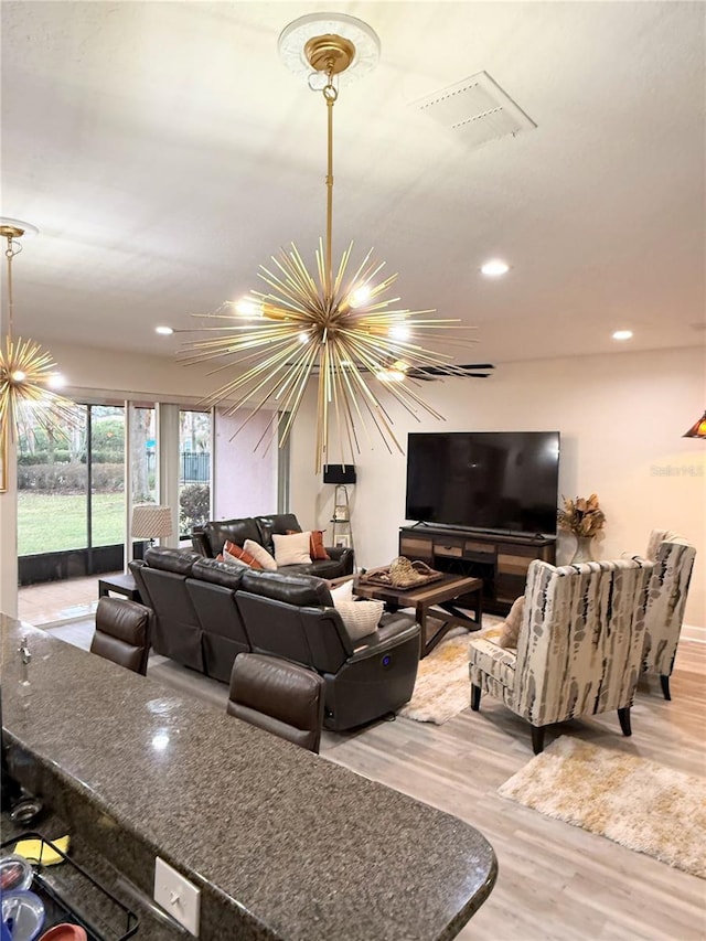 living room with a chandelier and light wood-type flooring