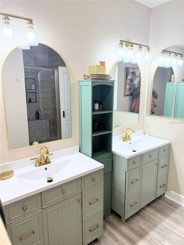 bathroom with a shower with door, hardwood / wood-style flooring, and vanity