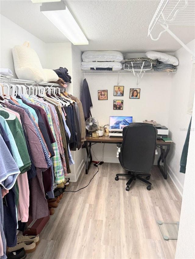 office area with light wood-type flooring and a textured ceiling