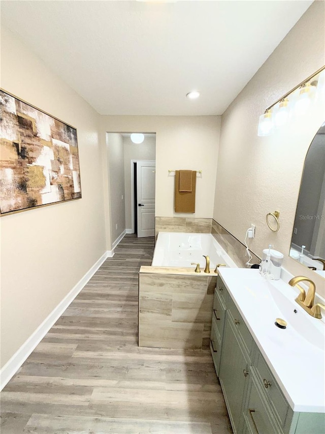 bathroom with vanity, a washtub, and hardwood / wood-style floors