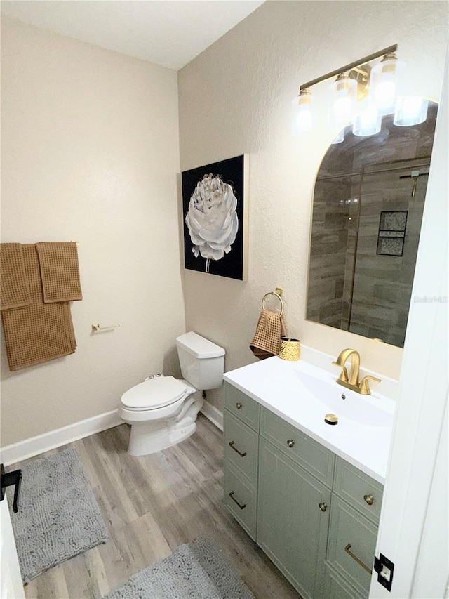 bathroom with toilet, hardwood / wood-style flooring, and vanity