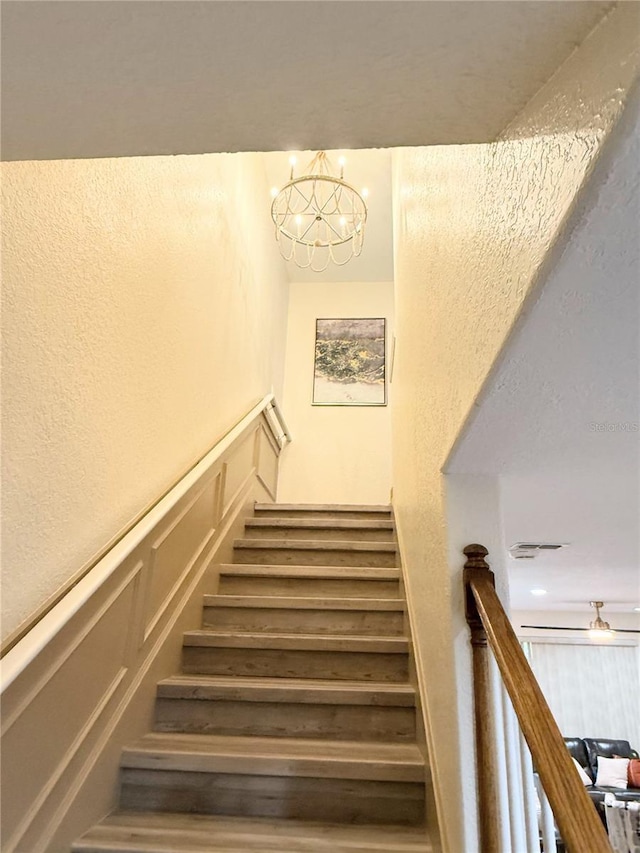 stairs featuring an inviting chandelier