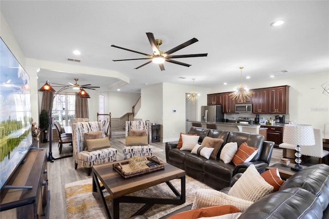 living room featuring ceiling fan and light hardwood / wood-style floors