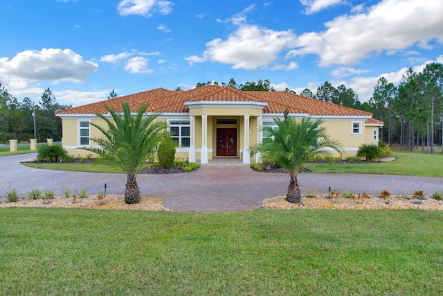 mediterranean / spanish home with a front lawn