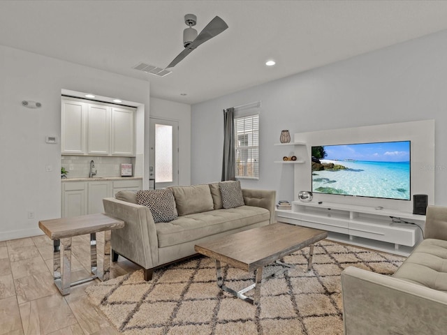 living room featuring sink, ceiling fan, and light wood-type flooring