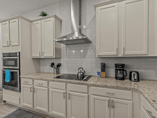 kitchen featuring black electric cooktop, wall chimney exhaust hood, double oven, and backsplash