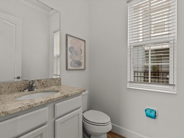 bathroom with crown molding, vanity, toilet, and hardwood / wood-style floors