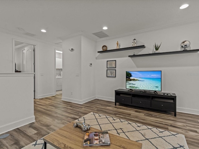 living room featuring crown molding, washer / clothes dryer, and dark wood-type flooring