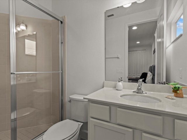 bathroom featuring an enclosed shower, vanity, and toilet