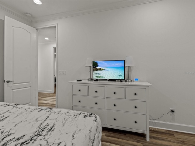 bedroom with ornamental molding and dark hardwood / wood-style flooring