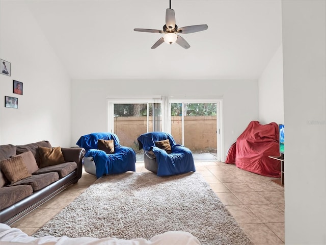 living room with ceiling fan, light tile patterned floors, and vaulted ceiling