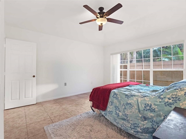 tiled bedroom featuring ceiling fan