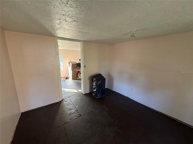 unfurnished room with a textured ceiling