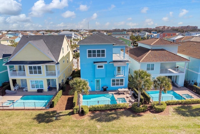 back of property featuring a fenced in pool, a lawn, a patio area, and solar panels