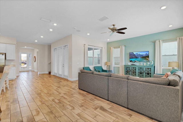 living room with plenty of natural light, ceiling fan, and light hardwood / wood-style flooring