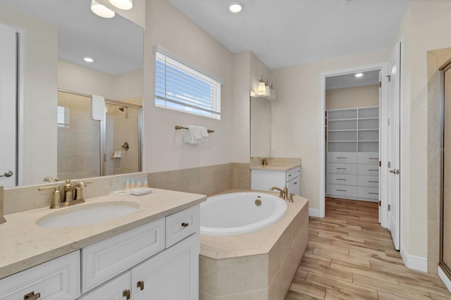 bathroom with vanity and shower with separate bathtub