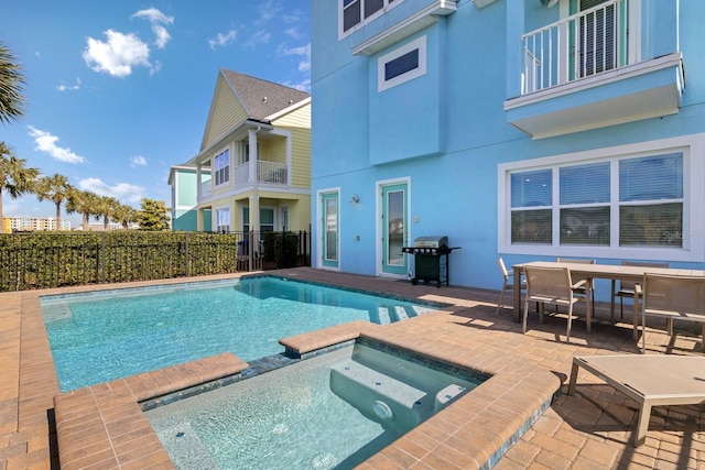 view of pool featuring grilling area, a patio, and an in ground hot tub