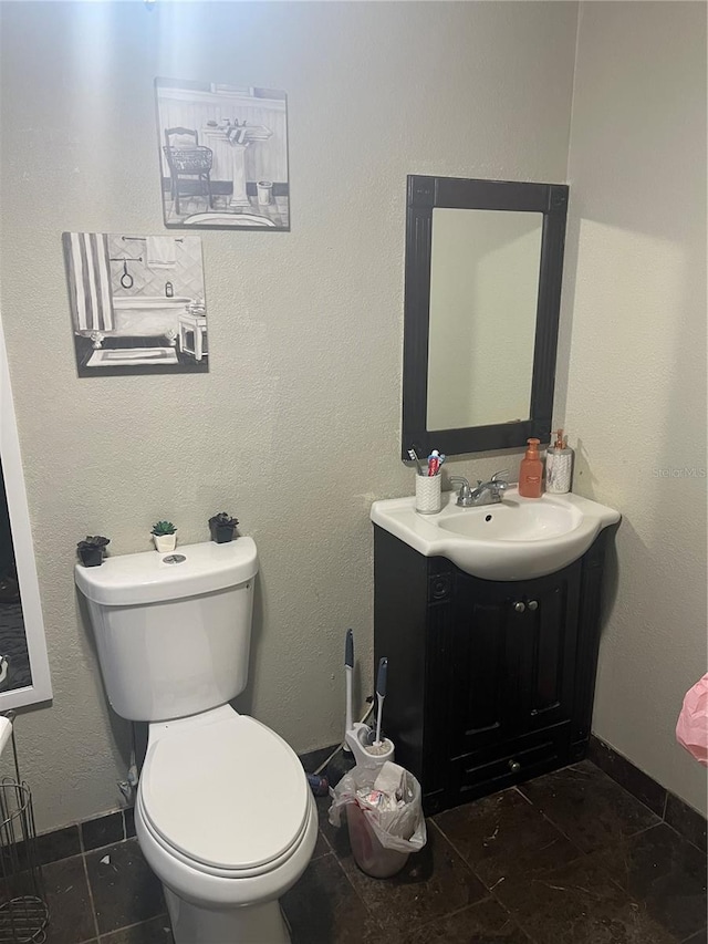 bathroom with toilet, tile patterned floors, and vanity