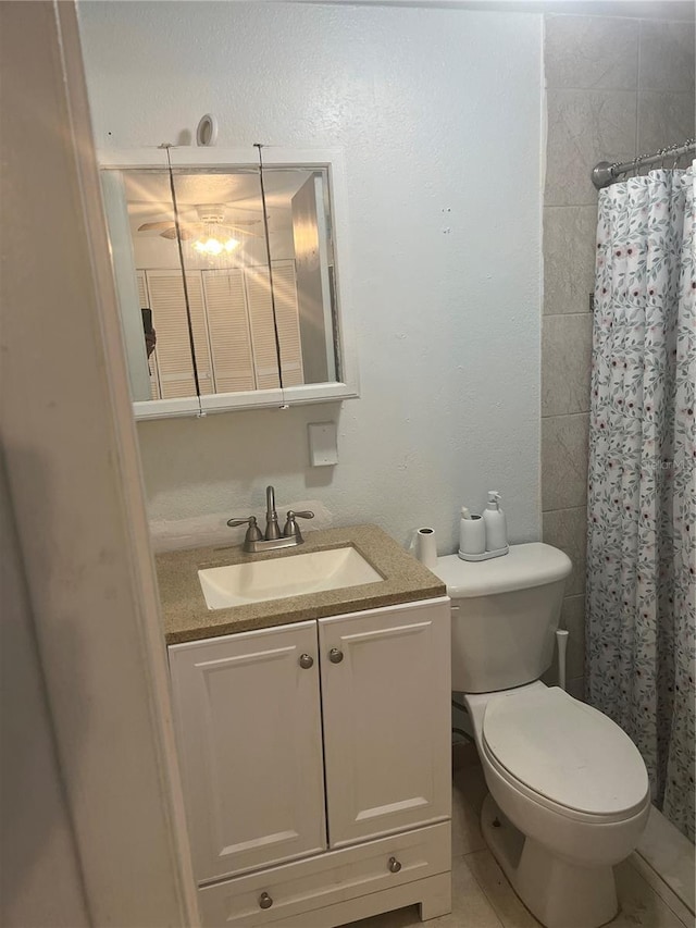 bathroom with tile patterned floors, toilet, vanity, and a shower with curtain