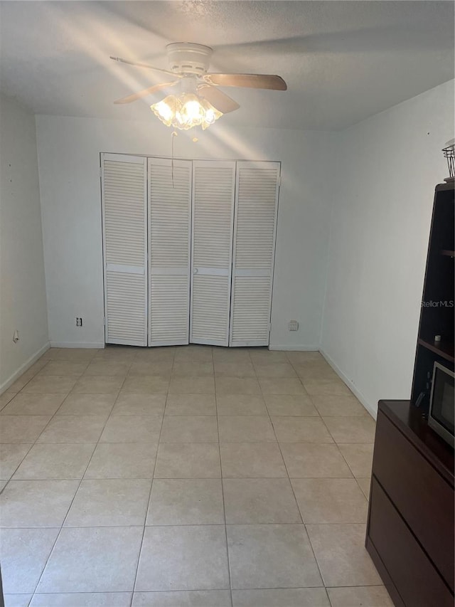 unfurnished bedroom featuring ceiling fan and light tile patterned floors