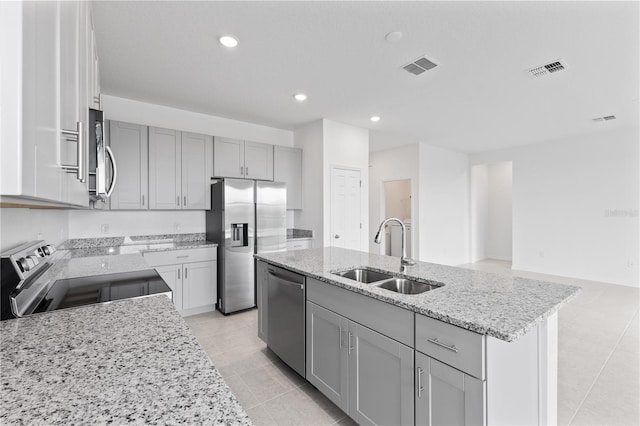 1343 Foran Manor Rd, Haines City, FL 33844 - kitchen featuring stainless steel appliances, light stone counters, light tile patterned floors, gray cabinets, and a kitchen island with sink
