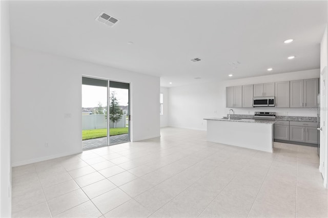 1343 Foran Manor Rd, Haines City, FL 33844 - kitchen with stainless steel appliances, gray cabinetry, recessed lighting, open floor plan, and light tile patterned floors