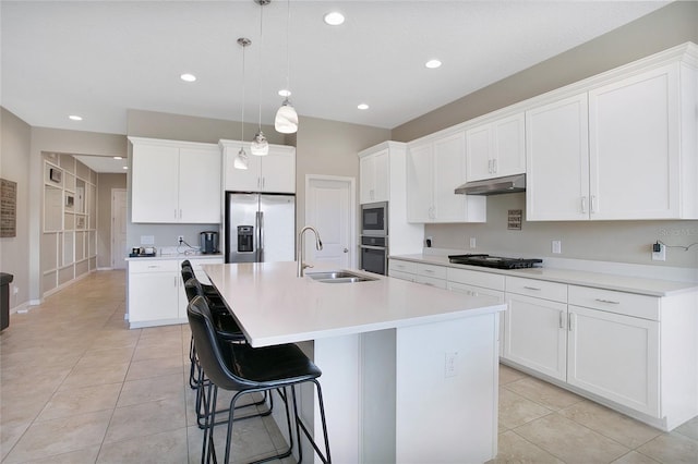 kitchen with pendant lighting, sink, white cabinets, a center island with sink, and stainless steel appliances