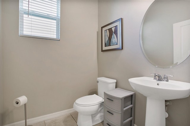 bathroom with sink, toilet, and tile patterned flooring