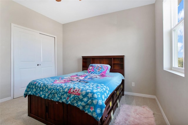 bedroom featuring a closet, ceiling fan, and light carpet