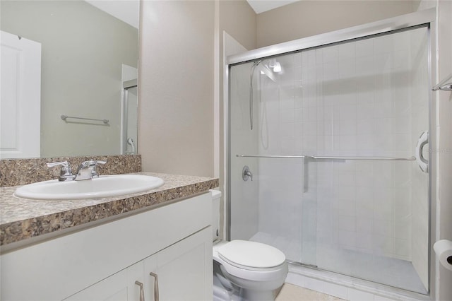 bathroom with vanity, toilet, and a shower with shower door